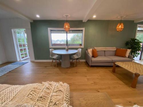 a living room with a couch and a table at Modern Apartment w/ Private Deck & BEAUTIFUL VIEWS in Topanga