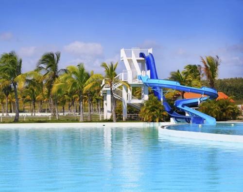 un tobogán de agua en una piscina con un complejo en Suites Town Center Playa blanca, en Playa Blanca