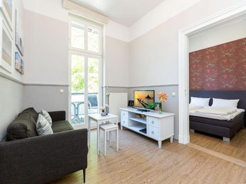 uma sala de estar com um sofá e uma cama em Villa Amelia App 05 em Heringsdorf