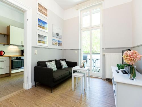 uma sala de estar com um sofá e uma mesa em Villa Amelia App 05 em Heringsdorf