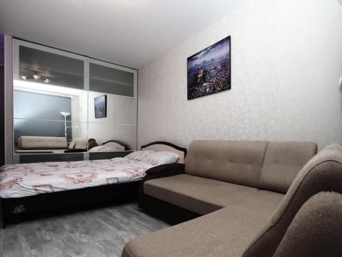 モスクワにあるApartLux Dubiniskayaのベッド1台とソファが備わる小さな客室です。