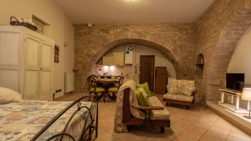 a living room with a bed and a dining room at La Chiocciola Assisi in Assisi