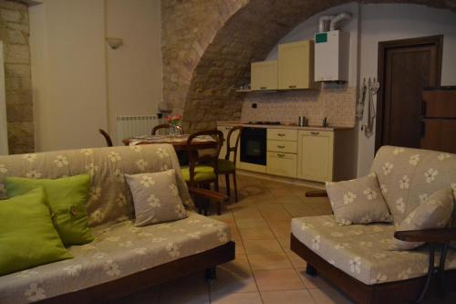 ein Wohnzimmer mit einem Sofa und einer Küche in der Unterkunft La Chiocciola Assisi in Assisi