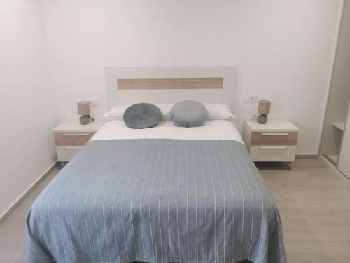 sypialnia z łóżkiem z 2 niebieskimi poduszkami w obiekcie Casa Cainzal w mieście Foz