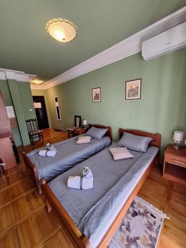 a bedroom with two beds with towels on them at Guest House Villa Lord in Novi Sad