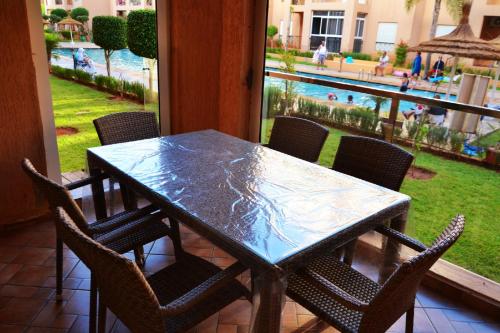 a table and chairs with a view of a pool at Reco flores PALM in O Ben Slimane