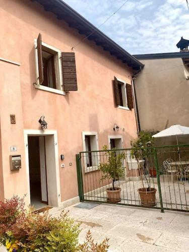 a pink house with a fence in front of it at Casa Cà Orsa in Cavaion Veronese