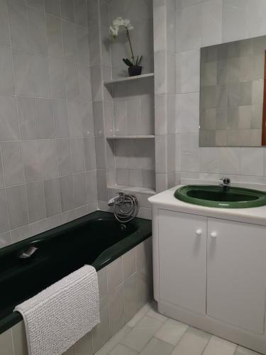 a bathroom with a green sink and a bath tub at Pension Yna Holiday in Málaga