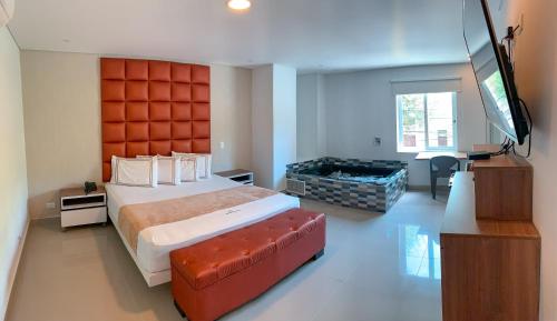 1 dormitorio con 1 cama grande y TV de pantalla plana en Infinity Hotel, en Medellín