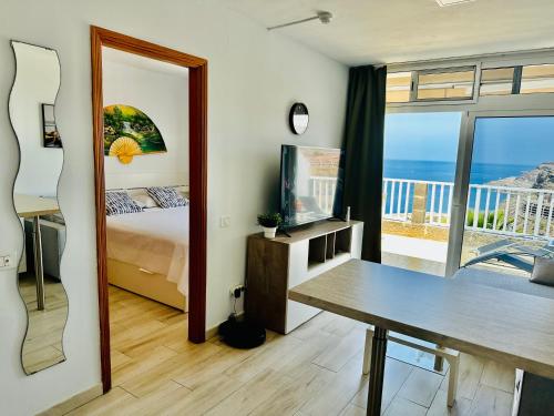 a bedroom with a bed and a view of the ocean at AMADORES BALCONY - WITH OCEAN VIEW. in Amadores