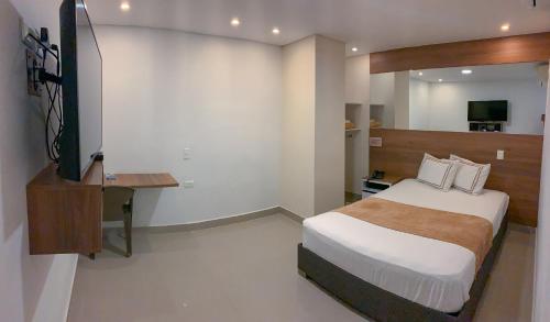 1 dormitorio con 1 cama y TV en Infinity Hotel, en Medellín
