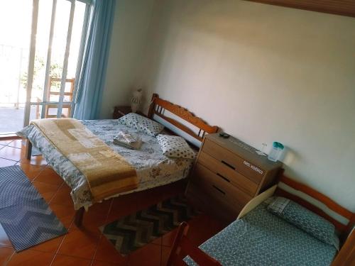 a bedroom with a bed with a dresser and a window at Pousada Colina Da Neve in São Joaquim