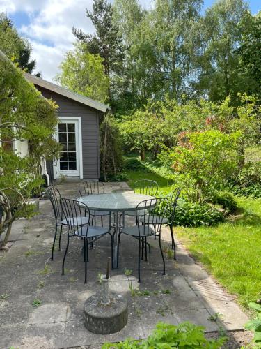 a patio with a table and chairs in a yard at A true nature pearl in idyllic surroundings but close to the city in Holbæk