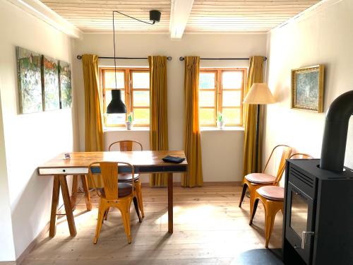a dining room with a wooden table and chairs at A true nature pearl in idyllic surroundings but close to the city in Holbæk