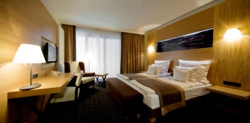 a hotel room with a bed and a desk at Grand Nosalowy Dwór in Zakopane