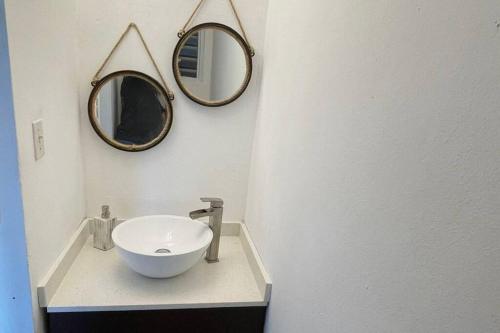a bathroom with a sink and two mirrors on the wall at Peaceful Luxury Villa - TheShine&GlowPlace in Fajardo