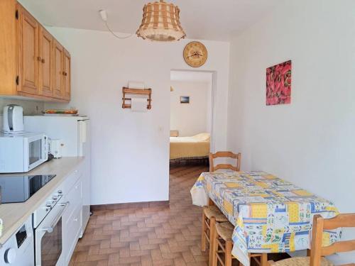 une cuisine avec une table et une cuisine avec une table et des chaises dans l'établissement COLIBRI, à Lit-et-Mixe