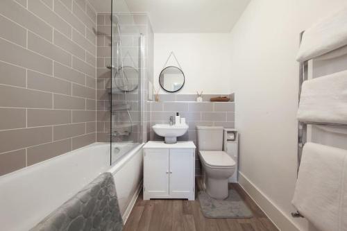 y baño con lavabo, aseo y bañera. en Stylish Well-Furnished Haven., en South Ockendon