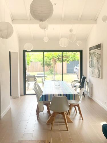 une salle à manger avec une table et des chaises dans l'établissement Villa - Montalivet les bains - 450m Océan, à Vendays-Montalivet