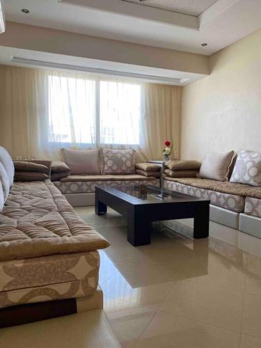 - un salon avec un canapé et une table basse dans l'établissement appartement neuf ensoleillé avec parking sous sol, à Agadir