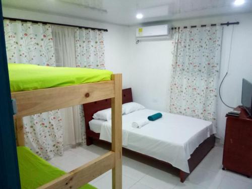 1 dormitorio con 2 literas y TV en CABAÑAS NATIVAS MISS FLASSY San Andres (Islas) en San Andrés