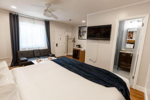 a bedroom with a large white bed and a flat screen tv at Ocean View Terrace in Hampton Bays