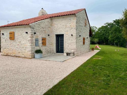 a stone building with a door in a yard at Villa Ondina - private pool in Brtonigla