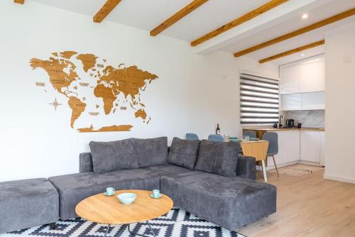 a living room with a gray couch and a world map on the wall at Vikendica 137 in Smederevo