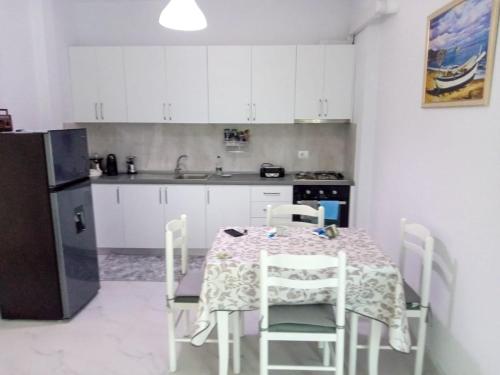 a kitchen with a table and chairs and a refrigerator at Orik Apartament in Vlorë