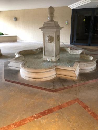 une fontaine dans un bâtiment avec des livres au sol dans l'établissement Front sea Luxury, à Cagnes-sur-Mer