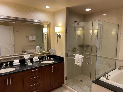 a bathroom with two sinks and a glass shower at MGM SIGNATURE - Balcony Suite Strip View - FREE valet parking in Las Vegas