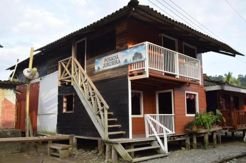 a tiny house with a porch and a balcony at Posada Jurubirá in Nuquí