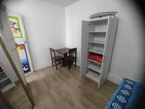 a room with a table and a chair and a closet at 717 Pizarro guesthouse in Trujillo