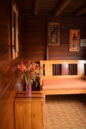 a room with two beds and a vase of flowers on a table at Posada Jurubirá in Nuquí