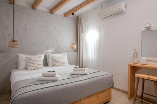a bedroom with a large white bed with towels on it at Elèa Concept Hotel & Suites in Gouves