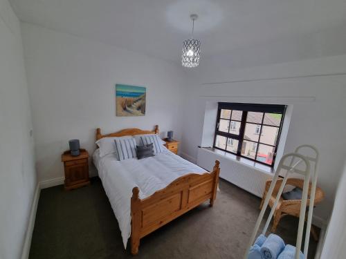 ein Schlafzimmer mit einem Holzbett und einem Fenster in der Unterkunft Brookmount House in Omagh