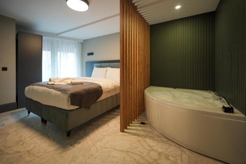 1 dormitorio con cama y bañera en Hotel Kurucesme Business en Estambul
