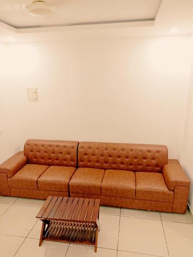 a brown couch in a room with a coffee table at THEKKUMPURAM RESIDENCY in Kondotti