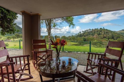 a table with a vase of flowers on a patio at Coffee Pickers Village By Hacienda Orosi in Cartago