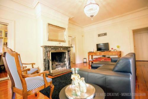 a living room with a couch and a fireplace at Wilmslow House in Goulburn