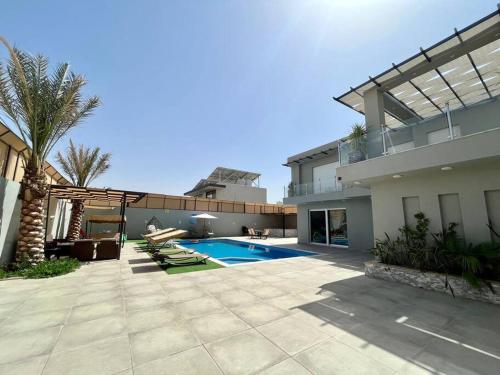 a backyard of a house with a swimming pool at Gloria Chalet in Al Rama