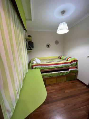 una habitación con un banco verde en una habitación en Apartamento Marichu, en Melide