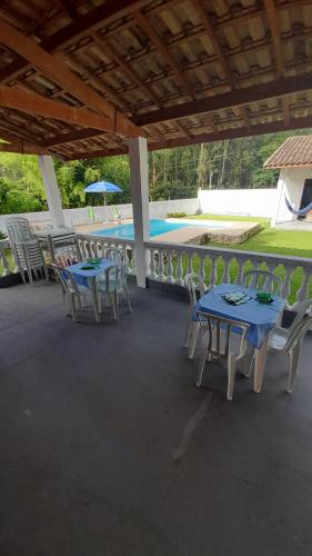 um pátio com mesas e cadeiras e uma piscina em Canto do Pássaro Aconcheg em São Bento do Sapucaí