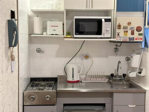 una pequeña cocina con fregadero y microondas en Guty en Buenos Aires