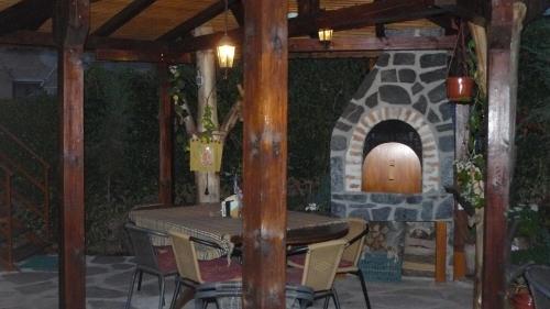 a table and chairs in front of a stone oven at Guesthouse Geto in Belogradchik