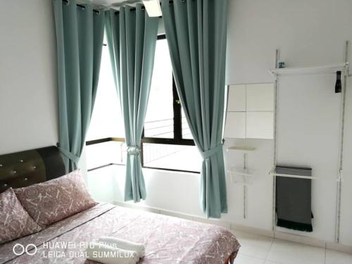 a bedroom with green curtains and a bed and a window at KNM Homestay Melaka in Ayer Keroh