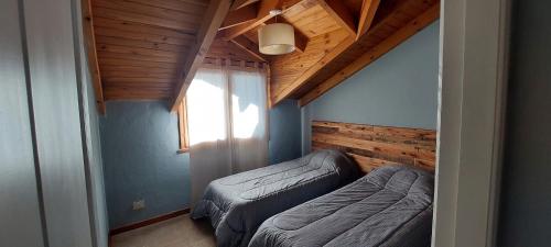 a small room with two beds and a window at Frambuesas Flat in Villa La Angostura