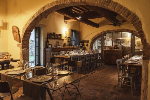 a restaurant with tables and chairs in a room at Podere Spedalone in Pienza