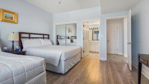a hotel room with two beds and a bathroom at Beachfront Spacious Renovated Condo - Pools, Hot Hub, Spa - Walk to Pier Park in PCB in Panama City Beach