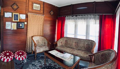 a living room with a couch and a table and a window at Koto Hilalang Homestay in Bukittinggi